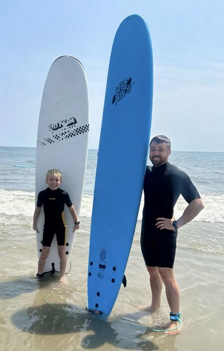Jordan at the beach with a surfboard